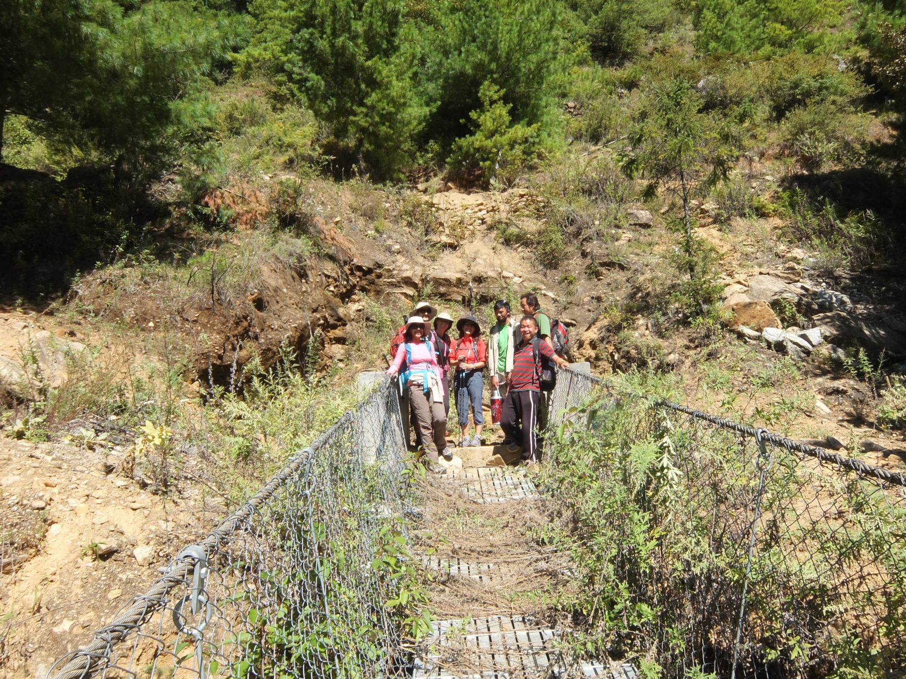 Bhutan Dagala Trek - Safely on the other side of the chain bridge, we pose to commemorate the official start of the trek. Bhutan Dagala Trek - Safely on the other side of the chain bridge, we pose to commemorate the official start of the trek.