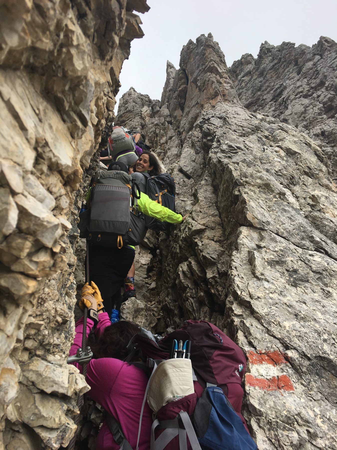Dolomites, Italy - We are climbing straight up and over using this narrow cut-out in the rock, with the help of occasional iron hand and foot holds and a cable-railing. Dolomites, Italy - We are climbing straight up and over using this narrow cut-out in the rock, with the help of occasional iron hand and foot holds and a cable-railing.